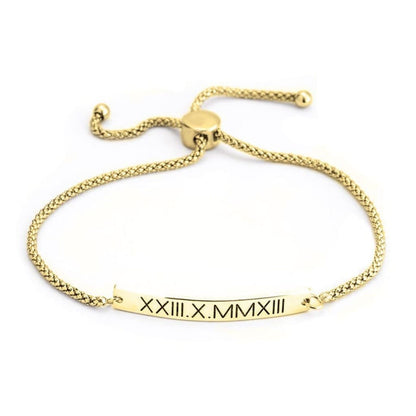 Gold bracelet with a bar featuring Roman numerals on a white background