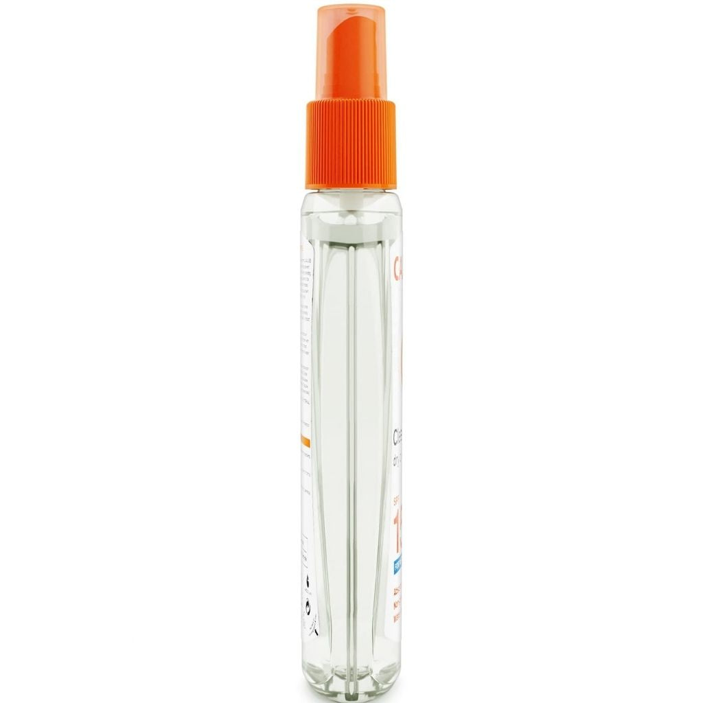 Clear spray bottle with an orange cap on a white background