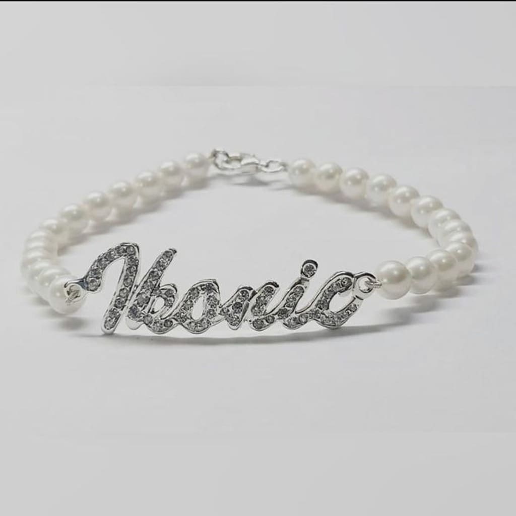 Pearl bracelet with silver 'Ivanic' charm on a light gray background