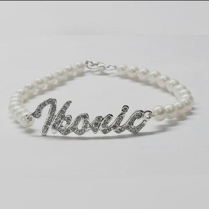 Pearl bracelet with silver 'Ivanic' charm on a light gray background