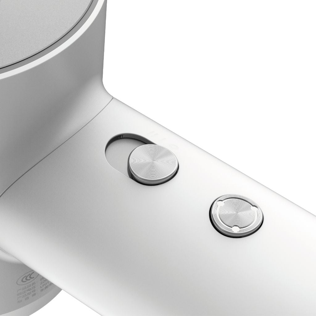 Close-up of a white electronic device with two silver buttons on a white background