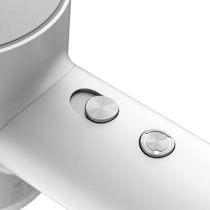 Close-up of a white electronic device with two silver buttons on a white background