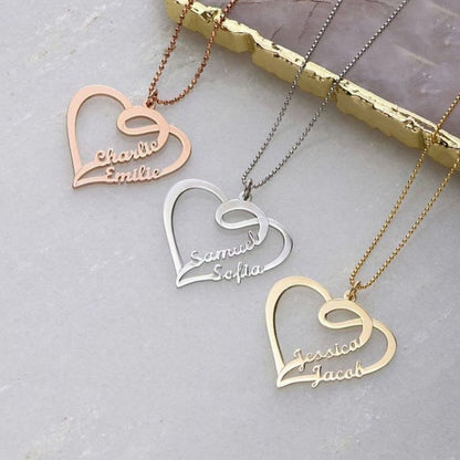 Heart-shaped name pendants on gold chains against a light gray background