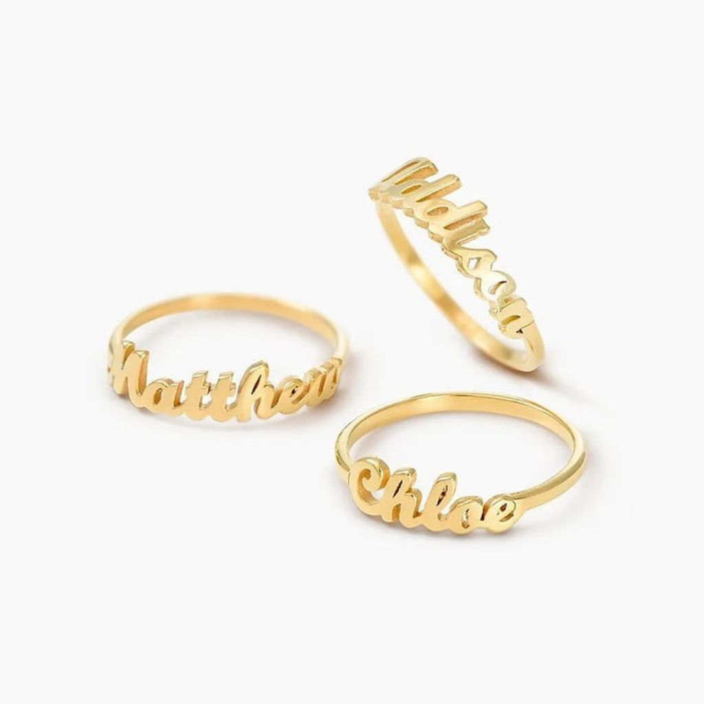 Three gold name rings on a white background