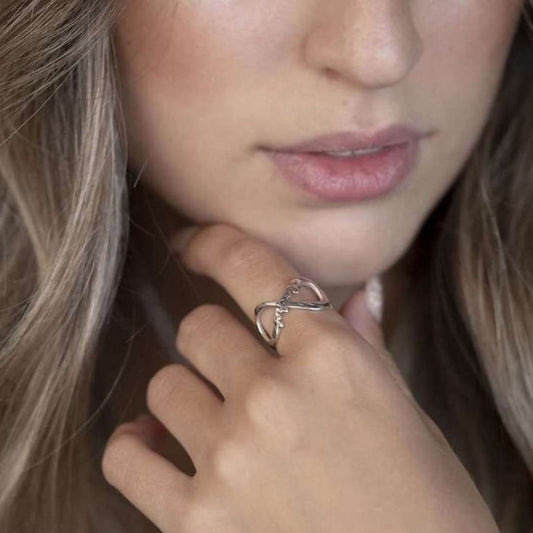 Close-up of a woman wearing a silver ring with a heart design.