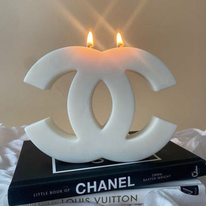 Candle shaped like the Chanel logo on top of a book