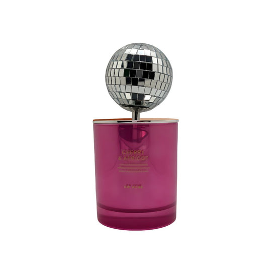 Pink candle with 'Cherry & Apricot' text next to a disco ball on a pink and beige background