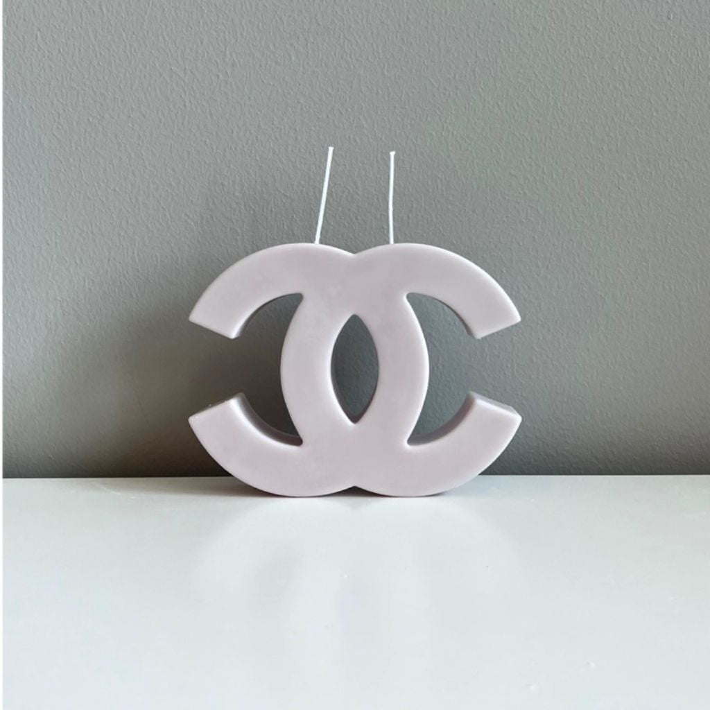 White candle shaped like a logo on a gray background