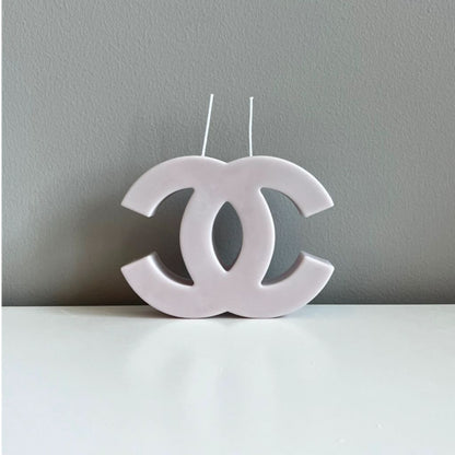 White candle shaped like a logo on a gray background