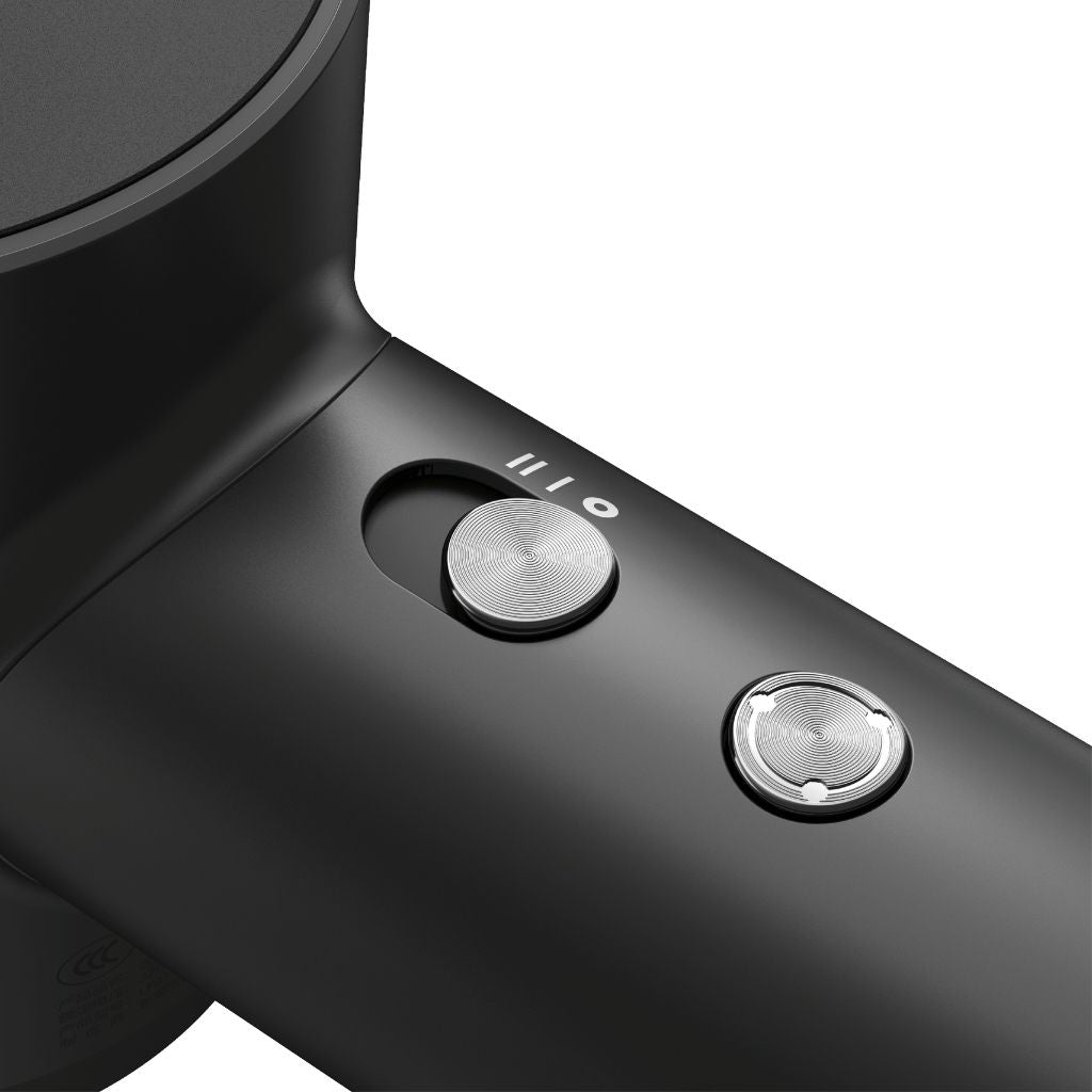 Close-up of a black hair dryer with control buttons on a white background