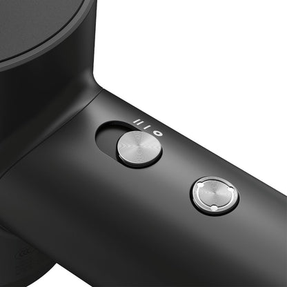 Close-up of a black hair dryer with control buttons on a white background