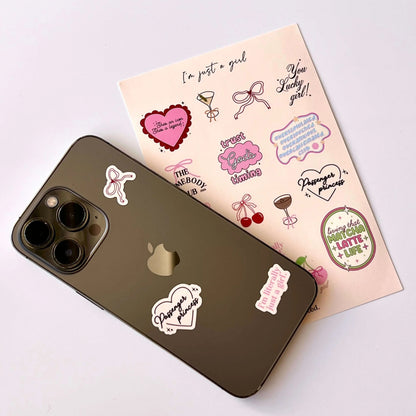 Phone with stickers and a sheet of additional stickers on a light background