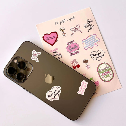Phone with stickers and a sheet of additional stickers on a light background