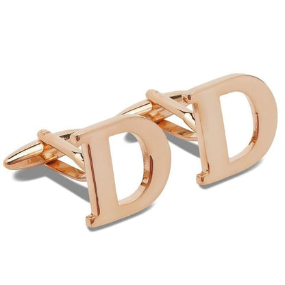 Rose gold cufflinks with 'D' initials on a white background
