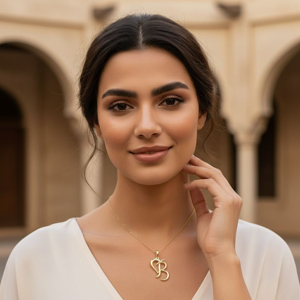 Woman wearing a gold necklace with a heart and 'S' pendant in an outdoor setting.