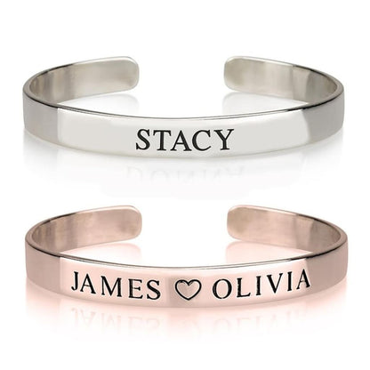 Two silver bangles with engraved names on a white background
