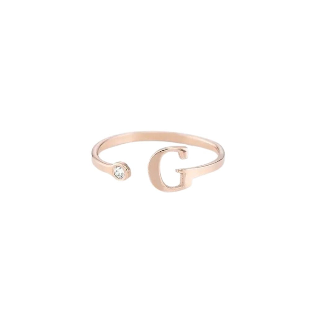 Rose gold bracelet with letter 'G' and small gemstone on a white background