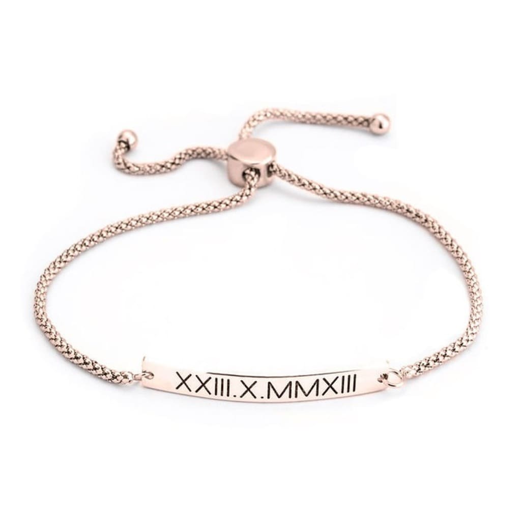 Rose gold bracelet with Roman numeral engraving on a white background