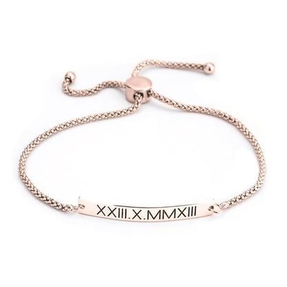 Rose gold bracelet with Roman numeral engraving on a white background