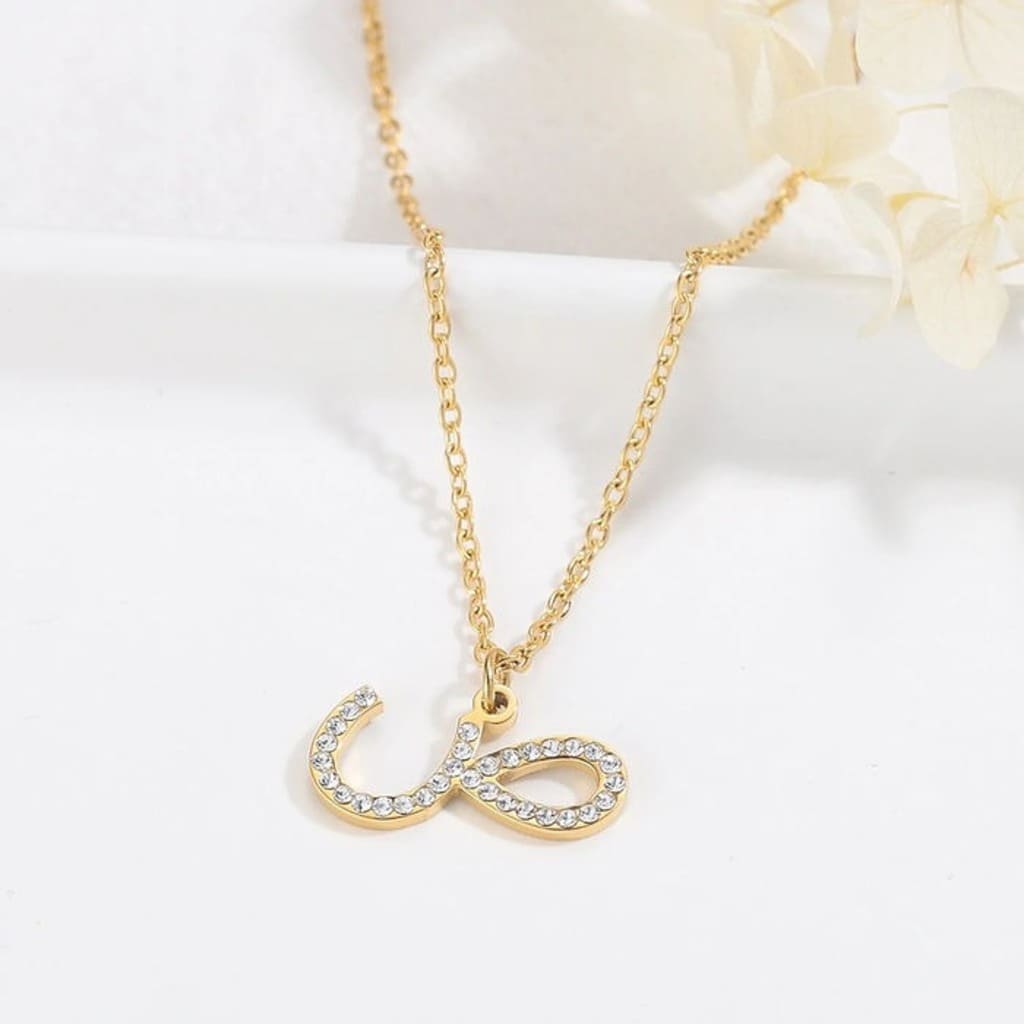 Gold necklace with a unique pendant on a light background