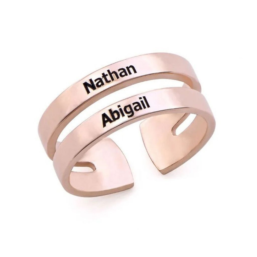 Rose gold ring with engraved names 'Nathan' and 'Abigail' on a white background