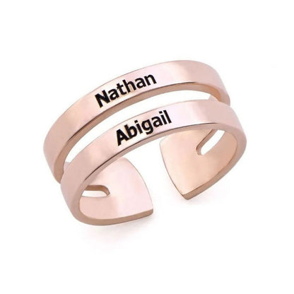 Rose gold ring with engraved names 'Nathan' and 'Abigail' on a white background