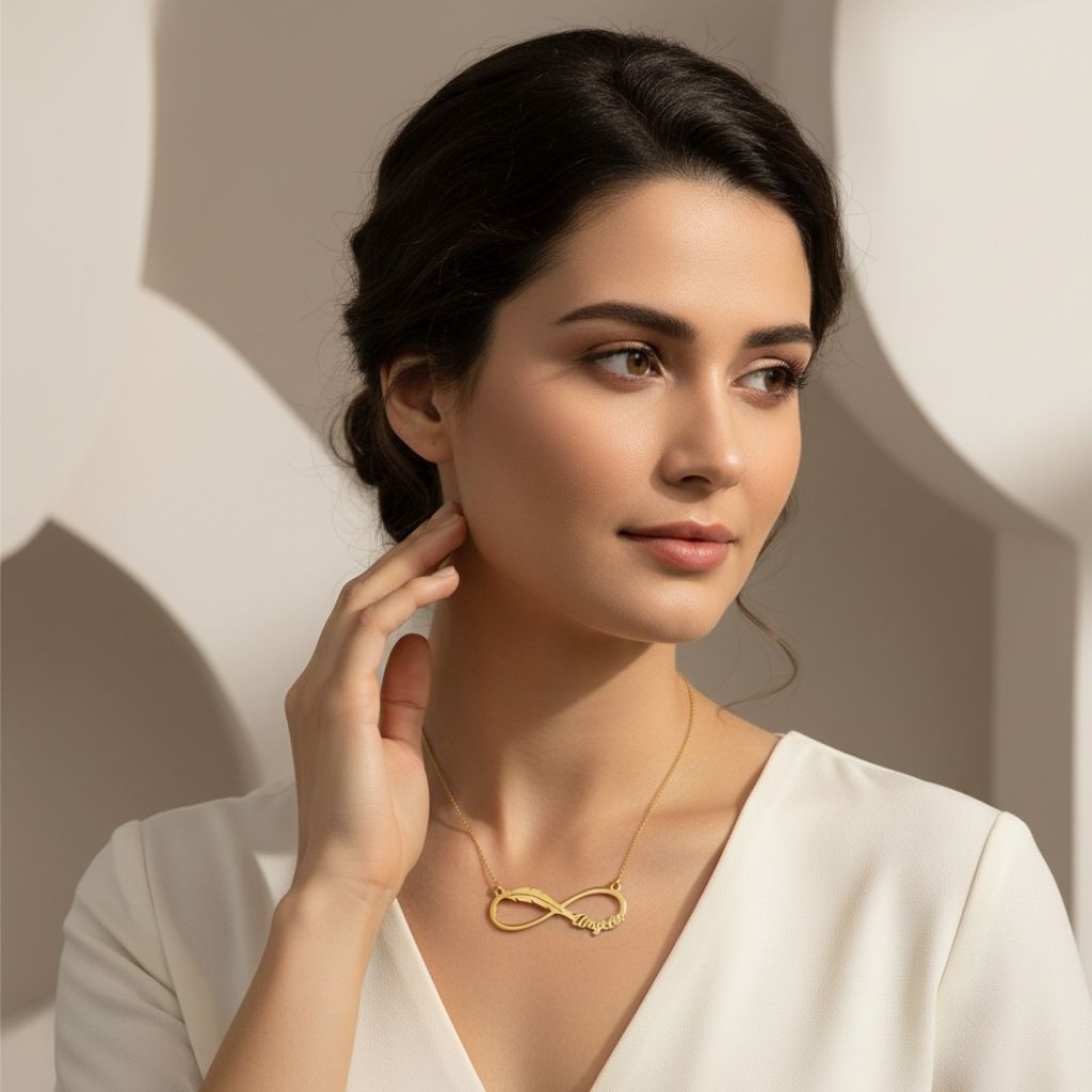 Woman wearing a gold necklace with an infinity symbol against a neutral background