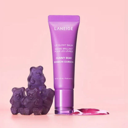 Purple Laneige lip balm with gummy bear toys on a pink background