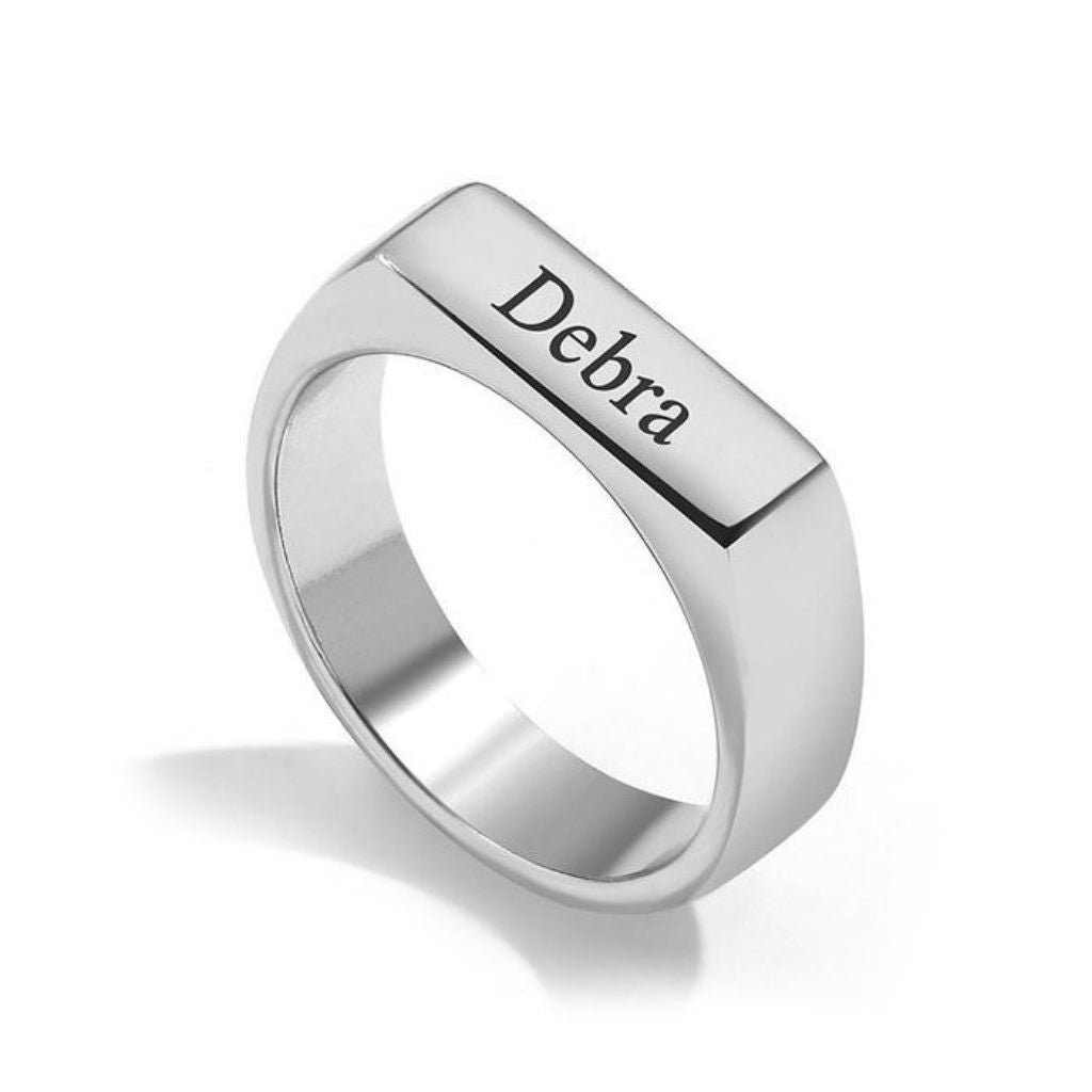 Silver ring with 'Debra' engraved on a white background
