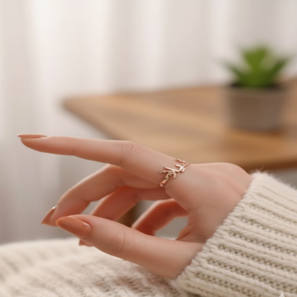 Hand wearing a delicate ring with a blurred indoor background