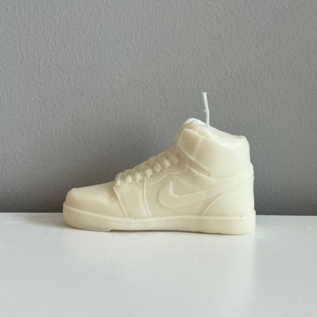 Candle shaped like a white sneaker with a Nike logo on a gray background