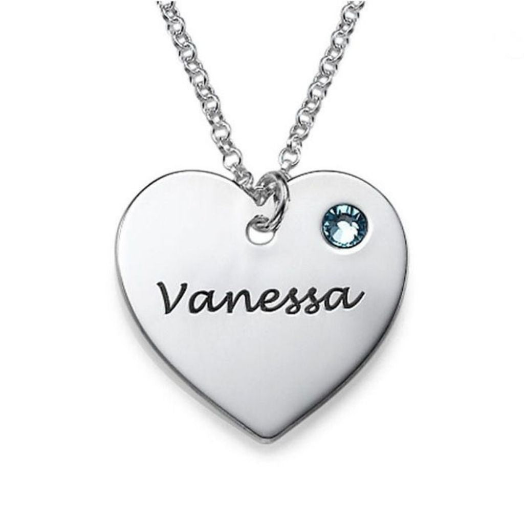 Heart-shaped necklace with engraved name 'Vanessa' and blue gemstone on a white background