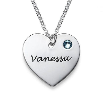 Heart-shaped necklace with engraved name 'Vanessa' and blue gemstone on a white background