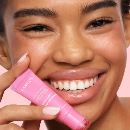 Woman holding a pink Laneige product against a pink background