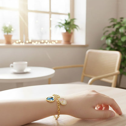Hand wearing a gold bracelet with a blue stone in a cozy room with a table and chairs.