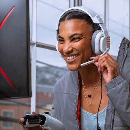 Woman wearing headphones and holding a gaming controller outdoors