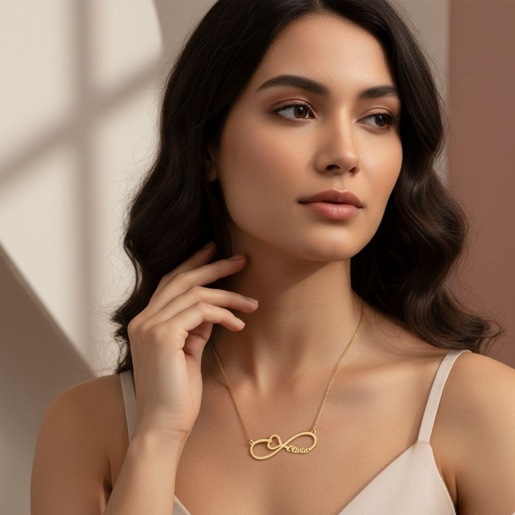 Woman wearing a gold necklace with an infinity symbol against a neutral background