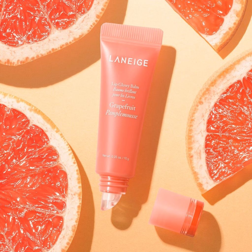Laneige lip balm tube with grapefruit slices on a yellow background
