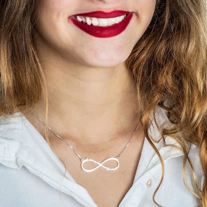 Woman wearing a silver infinity necklace with a blurred background