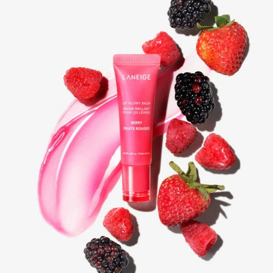 Laneige lip balm tube surrounded by strawberries and blackberries on a white background