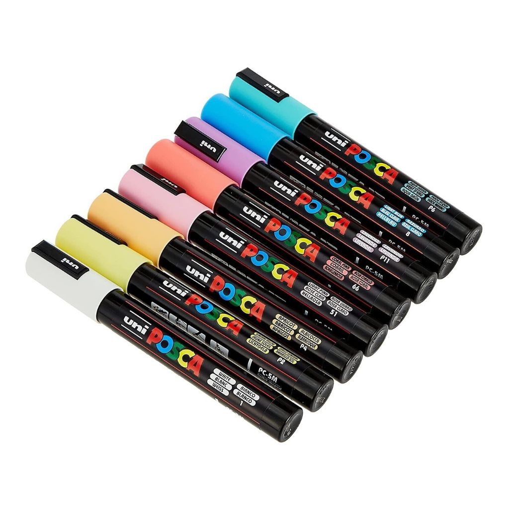 Set of Uni Posca markers in various colors on a white background