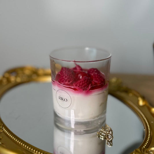 Glass dessert with raspberries on a gold tray
