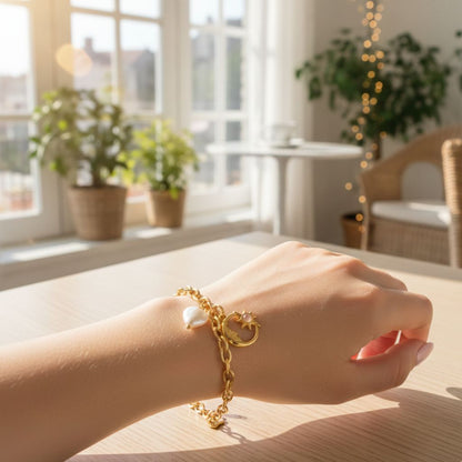 Gold bracelet with pearls on a hand in a bright room with plants