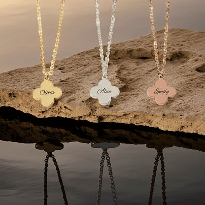 Three floral name pendants on chains against a natural background