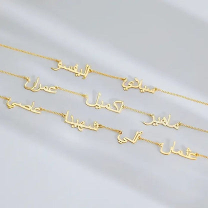 Gold necklaces with Arabic script on a light gray background