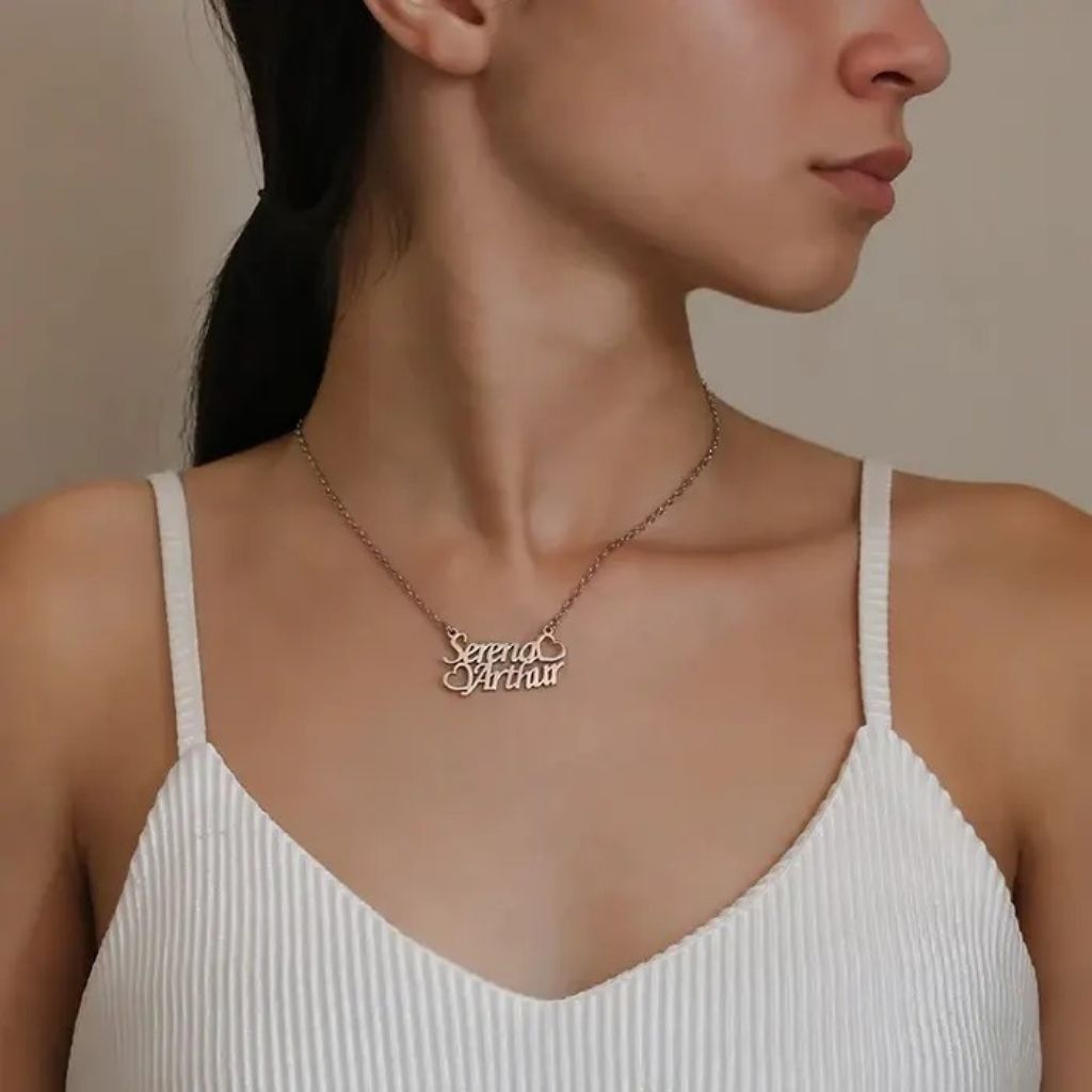 Woman wearing a necklace with 'Seraphina' pendant against a neutral background