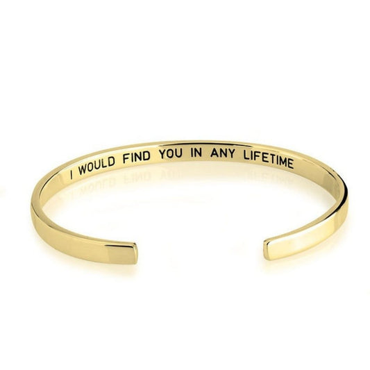 Gold bracelet with engraved message on a white background