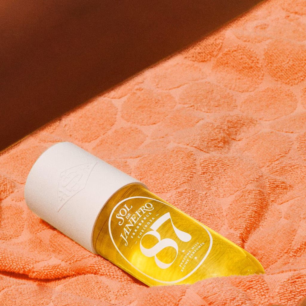 Yellow bottle with white cap on an orange textured surface