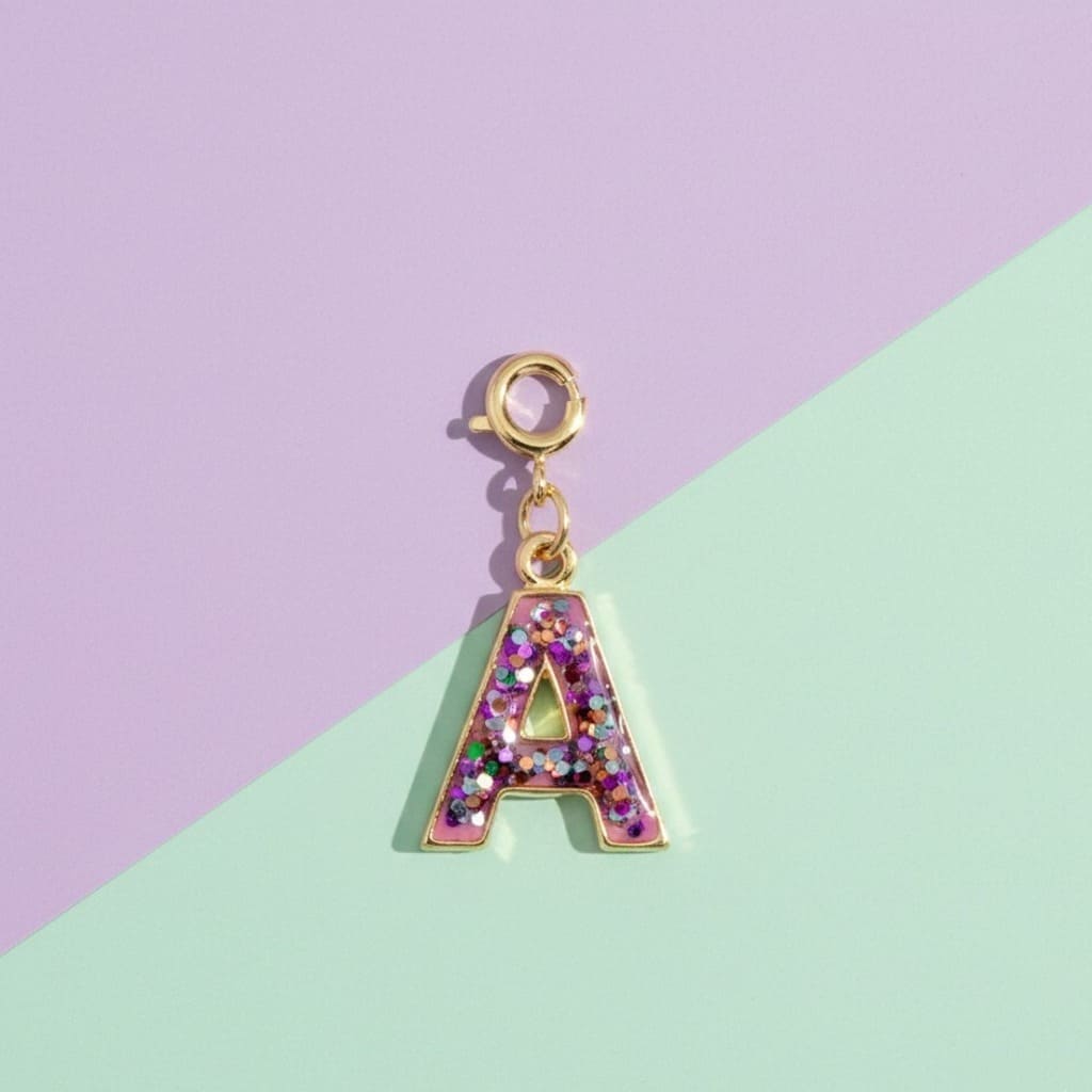 Gold letter 'A' charm with glittery design on a pastel purple and green background
