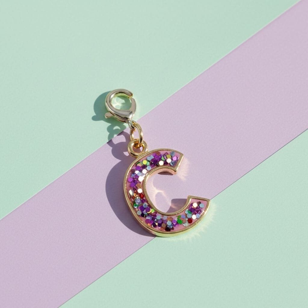 Letter 'C' charm with colorful stones on a pastel background